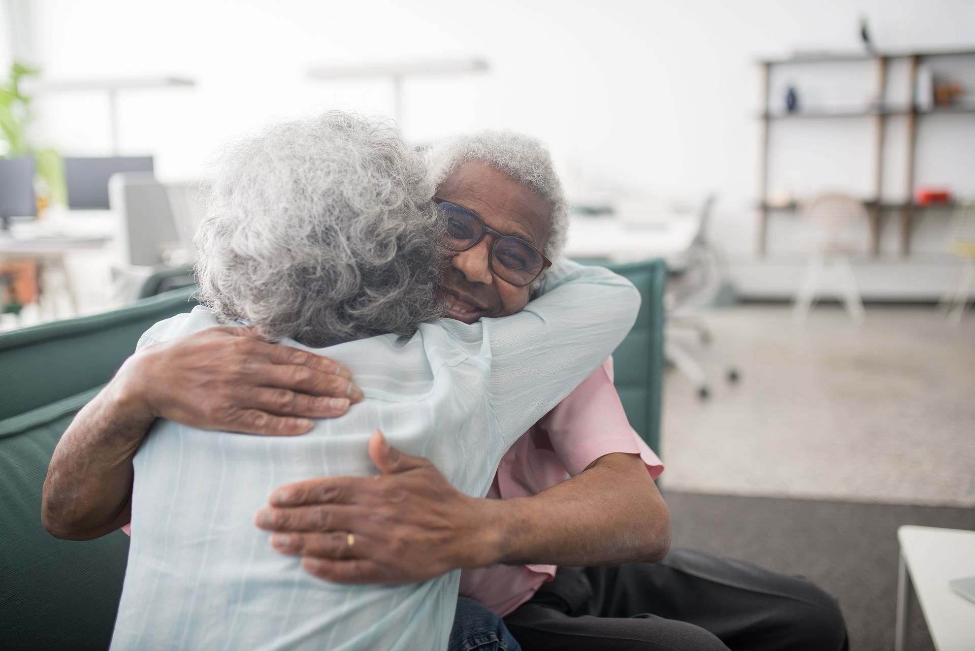 Senior couple warmly embracing and smiling indoors, showcasing love and happiness.